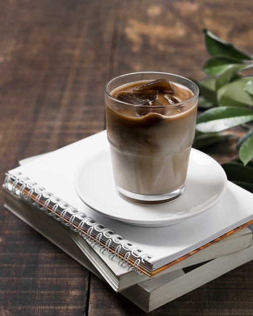 Photo high view delicious coffee in cup on pile of notebooks