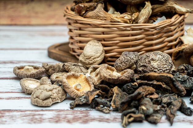 소박한 나무 테이블에 있는 고리버들 바구니에 말린 소나무 표고버섯과 굴 버섯의 높은 전망