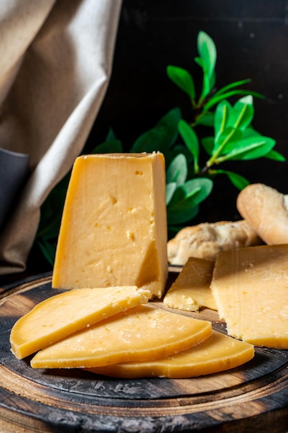 a high view of a piece of provolone cheese cut on a board. vertical orientation.