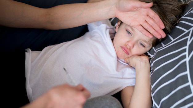 Photo high view sick child with fever