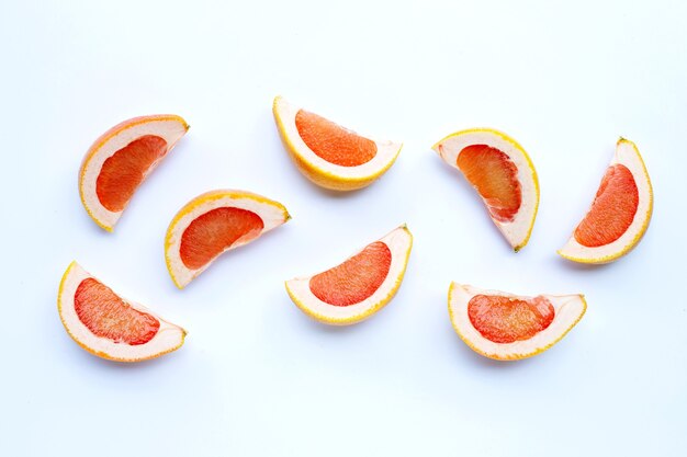 High vitamin C. Juicy grapefruit slices on white wall.