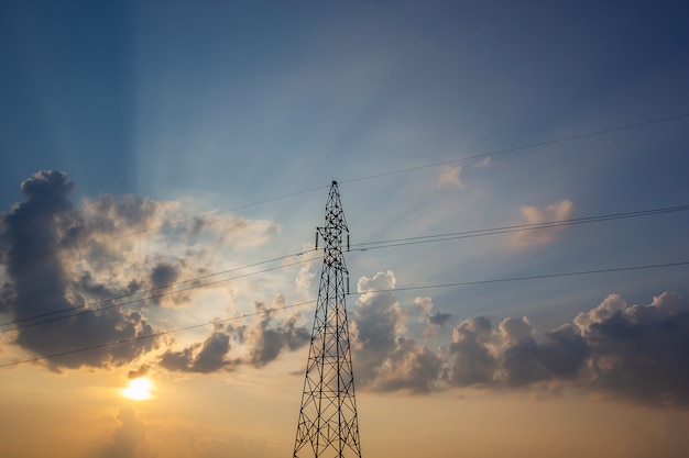 High Voltage Electric Power Lines On Pylons In Sunset. 