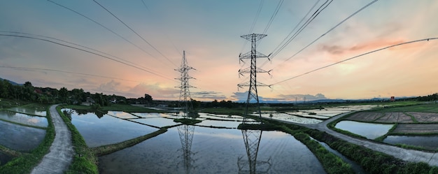 日没時間の高電圧電気塔と日没の背景の空。