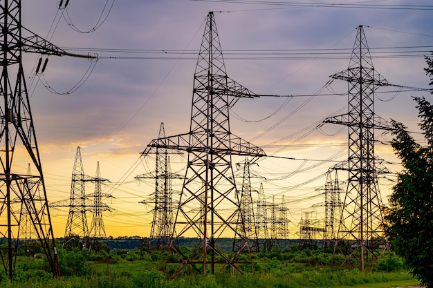 High voltage electrical substation over sunset background with transformers