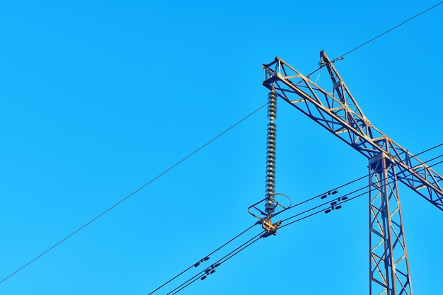 High voltage electricity tower with power line against blue sky Overhead electric power line with insulators Electricity generation transmission and distribution network Indastry landscape