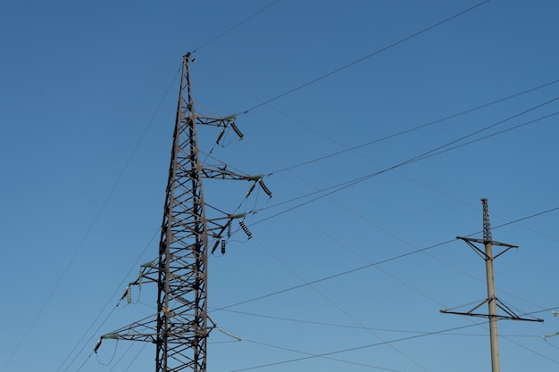 写真 澄んだ青い空と晴れた日の工業地帯の高圧線と送電鉄塔。