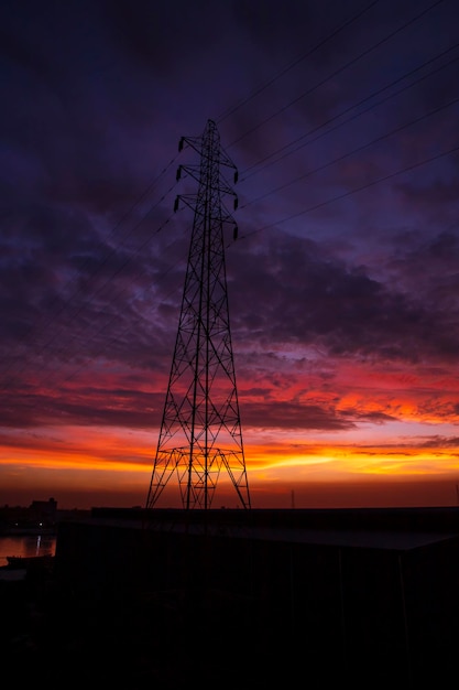 High voltage power line tower with beautiful sky at sunset stock photo