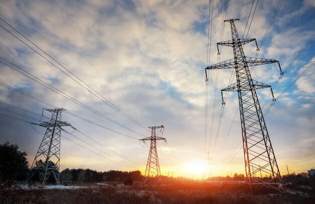 High-voltage power lines during fiery sunrise