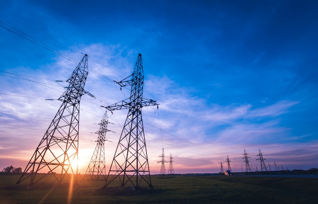 High-voltage power lines at sunset. Electricity distribution station.