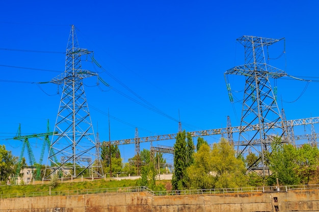 High voltage power lines towers on blue sky background