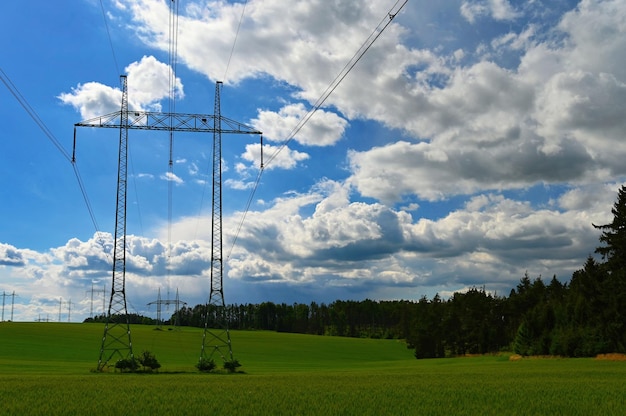 High voltage pylons Blue sky with clouds and sun in nature Concept for technology and industry