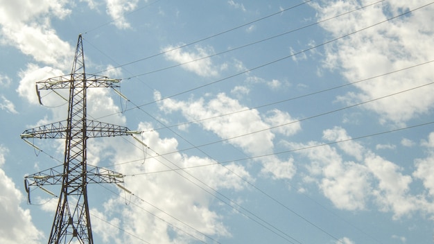 雲と青い空を背景に高電圧タワー