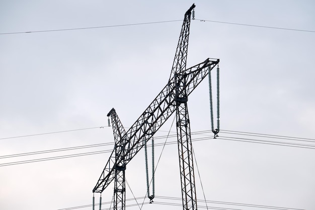 High voltage tower with electric power lines transfening electrical energy through cable wires