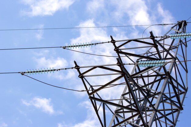 High voltage tower with electrical voltage wires isolates closeup against the background of clouds Energy industry