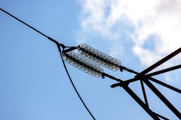 電圧線を備えた高圧鉄塔は、雲を背景にクローズアップを分離しますエネルギー産業