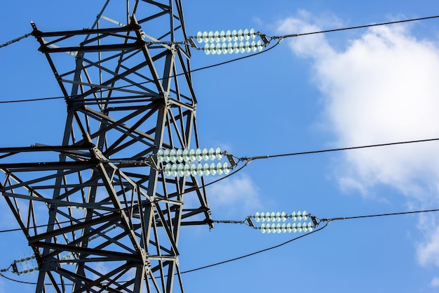 High voltage tower with electrical voltage wires isolates closeup against the background of clouds Energy industry