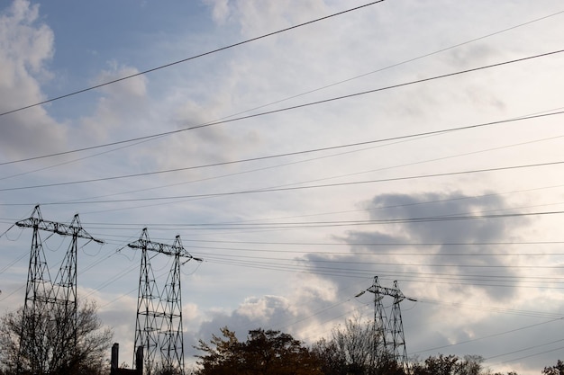 空を背景にした高電圧タワーとワイヤー