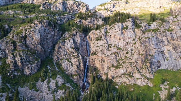 Foto un'alta cascata scende in cascata in una gola di montagna