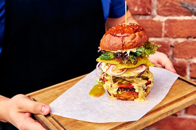 Photo highest burger on a tray in hands