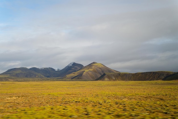 Highland in Iceland. Mountains with green moss on cloudy sky. Wilderness, northern nature. Travelling, discovery, adventure, wanderlust concept