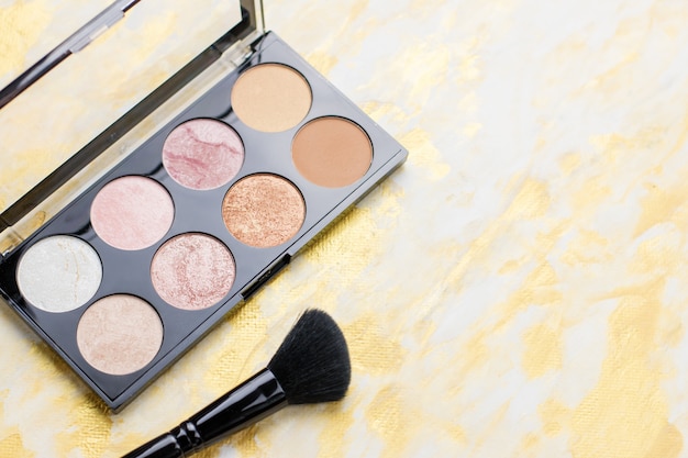 Highlighter palette closeup, make up cosmetics in black and gold.