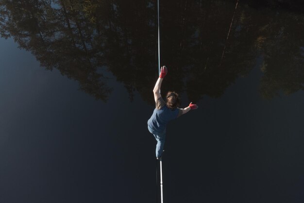 Foto highline over water de atleet loopt op een lijn boven het water epische luchtfoto
