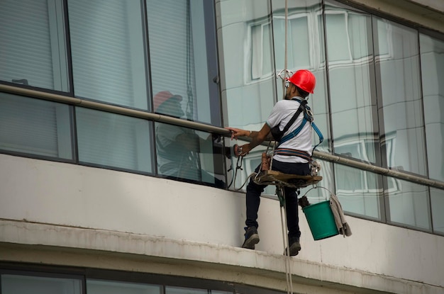 highrise glass cleaning tall building glass cleaner with helmet and protective clothing