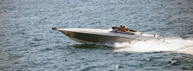 Highspeed boat goes fast in calm sea People enjoy the summer sport Panoramic view banner