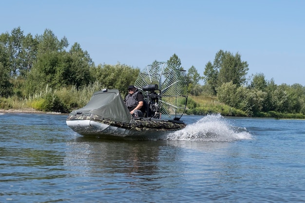 Highspeed riding in an airboat on the river on a summer day with splashes and waves