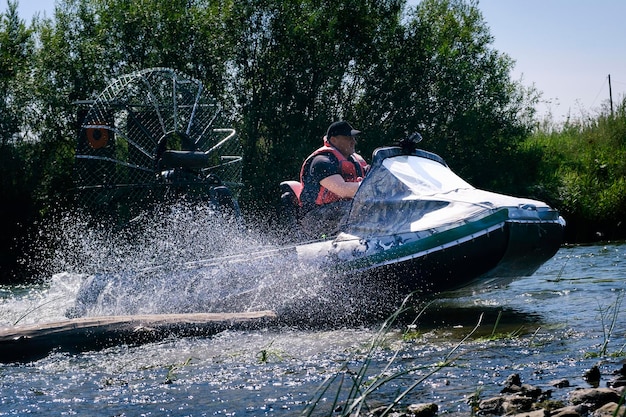 Foto guida ad alta velocità in un airboat sul fiume in una giornata estiva con spruzzi e onde