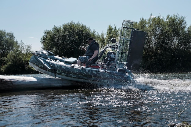 Foto highspeed rijden in een moerasboot op de rivier op een zomerdag met spetters en golven