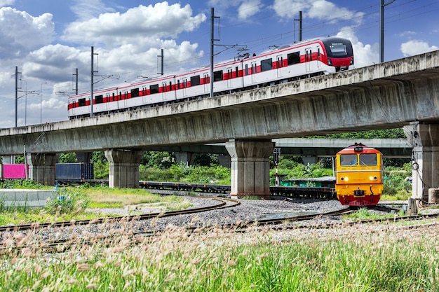 Highspeed trains and freight trains with cloudy sky