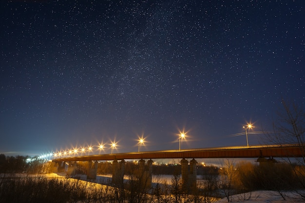Highway bridge with the stars and the Milky Way, lit by lanterns