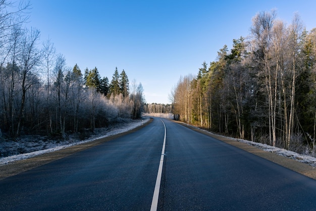 Highway Highways white line Asphalt road between frosty trees in the sunny day