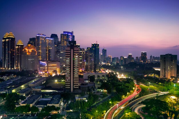 Photo highway junction with glowing skyscrapers