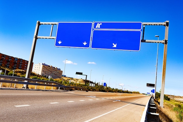 Highway road sign.Empty road through city with blank road-sign.