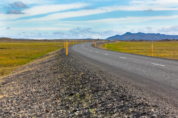 Highway through Icelandic landscape under a blue summer sky