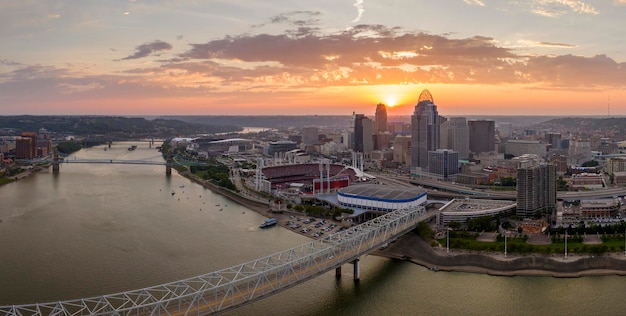 Photo highway traffic with driving cars on bridge in downtown district of cincinnati city in ohio usa american city skyline with brightly illuminated high commercial buildings at sunset