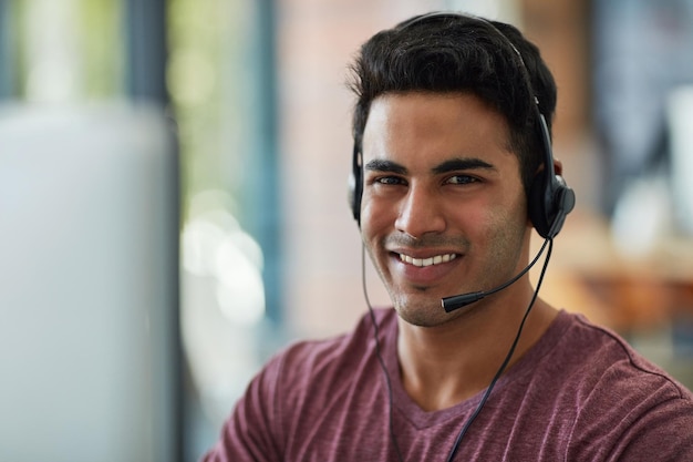 Hij handhaaft het vertrouwen in zijn bedrijf Shot van een jonge callcentermedewerker die aan zijn bureau werkt