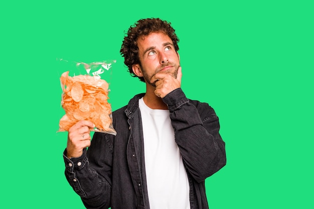 Hij kijkt zijwaarts met een twijfelachtige en sceptische uitdrukking.