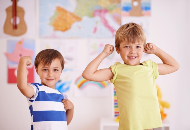 Hij wil net als zijn grote broer zijn. Twee jonge jongens die hun spieren spannen terwijl ze in hun slaapkamer staan