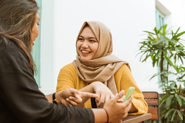 Hijab girls see friends while sitting chatting