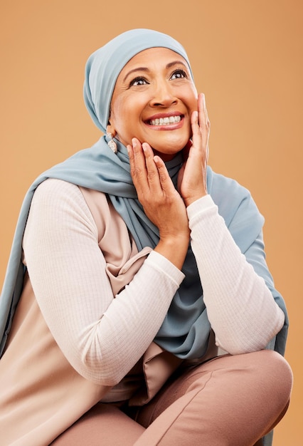 イスラム教徒のヒジャーブと成熟した顔と手を持つイスラムモデルの笑顔は、スキンケアの輝きと美しさに満足しています化粧品の豪華さと化粧とアラブ文化からの幸せを持つ女性の肌の健康
