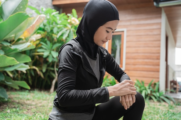 Hijab sportieve aziatische vrouw op zoek naar een slimme armband om de tijd in te stellen