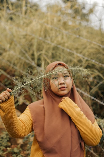 Foto hijab vrouw met plant in de tuin