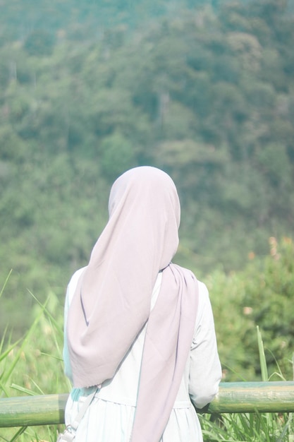 Photo hijab woman facing back looking at the view