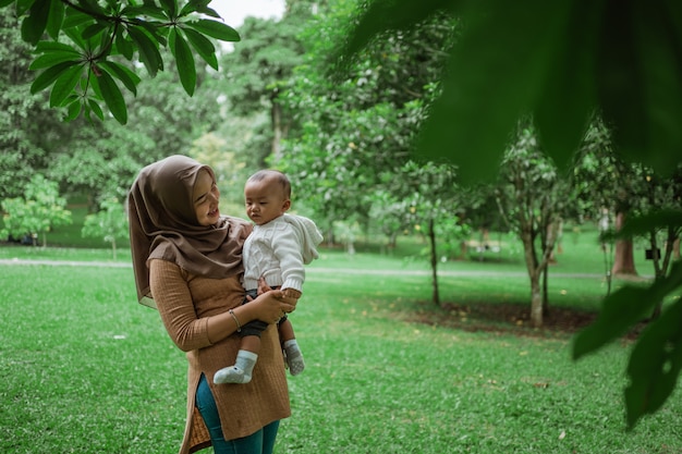 Hijab donna che tiene piccolo bambino