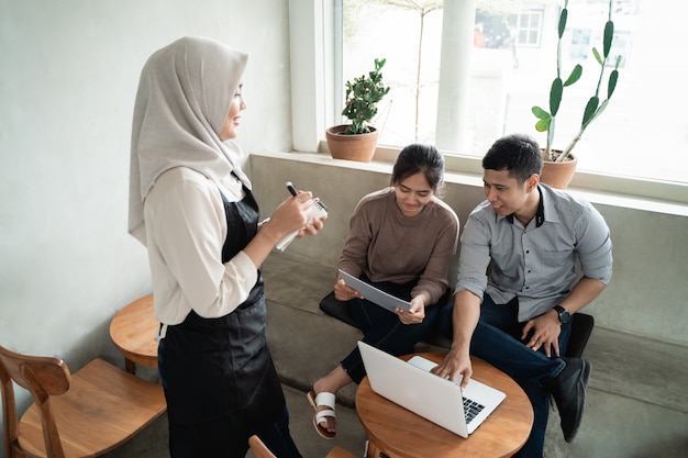 Hijab woman waiter write customer order