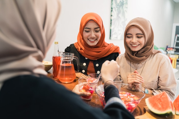 ヒジャーブの女性と友人が甘い飲み物で速く壊す