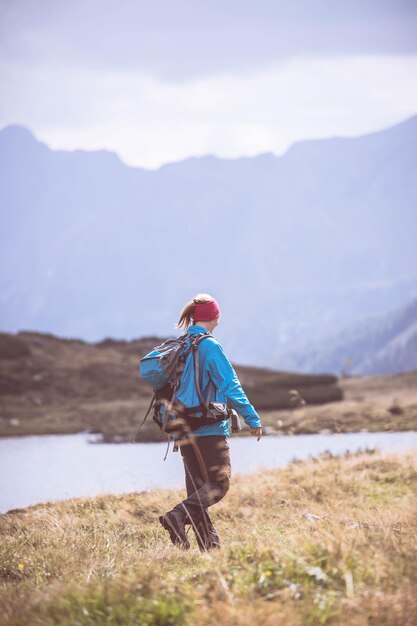 Hiker in boots and with backpack is walking un the upland Austria